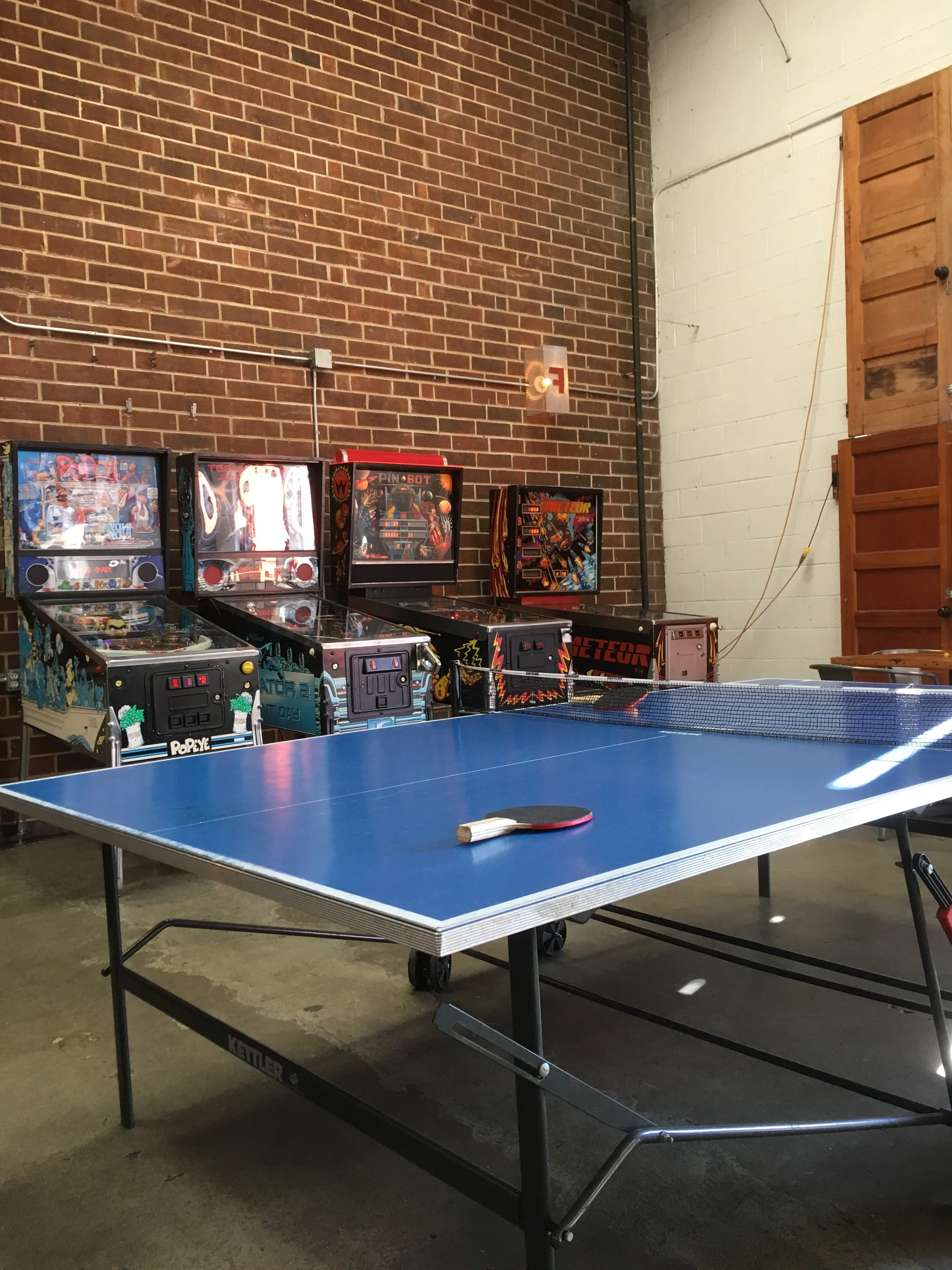 ping pong table with arcade games in back