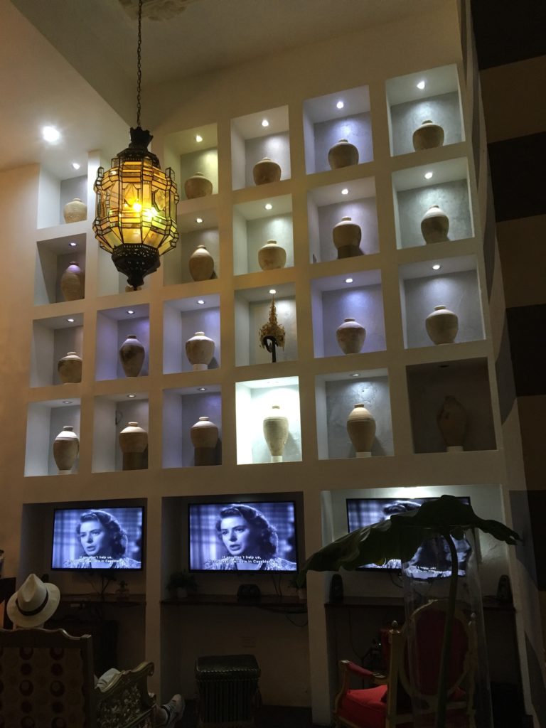 hotel in Old San Juan wall with jars and TVs showing the movie Casablanca
