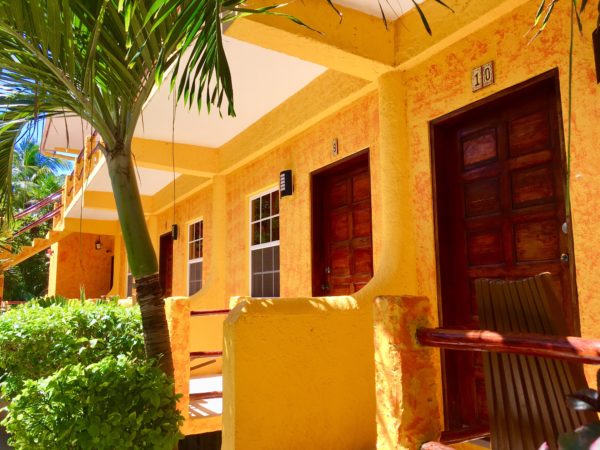 organge building with brown wooden doors in tropical hotel at Seaside Cabanas