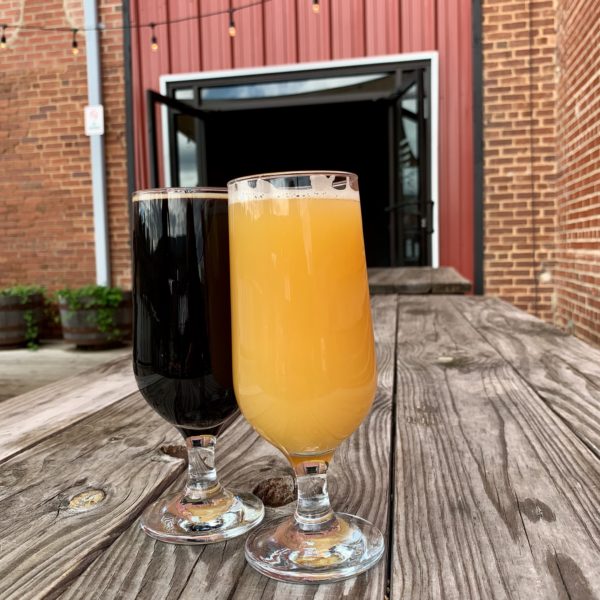 two glasses of beer in front of red building with open door - High Branch Brewing