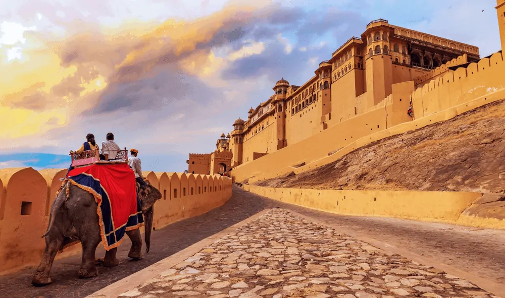 One month India itinerary featured by top travel blog, The Common Traveler. Jaipur fort with couple on elephant