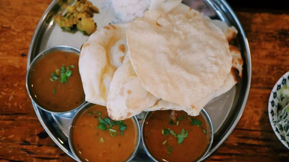 THE BEST THINGS TO DO IN DELHI, INDIA - A COMPLETE TRAVEL GUIDE TO INDIA'S HISTORIC CAPITAL featured by  The Common Traveler; Image: plate with Indian food