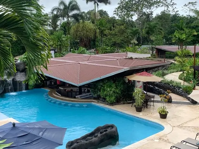 Arenal Springs Resort review featured by top international travel blogger, The Common Traveler | image: pool with springs and seats around swim up bar