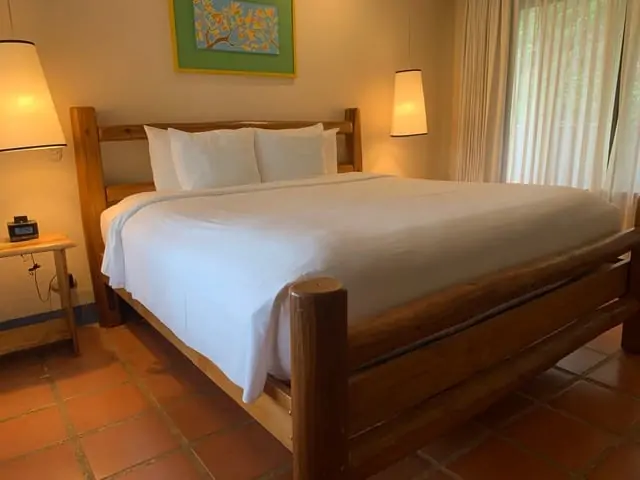 Hotel Punta Islita | The Common Traveler | image: Wooden frame king size bed with white sheets | Hotel Punta Islita by popular US international travel blog: image of a room at Hotel Punta Islita.