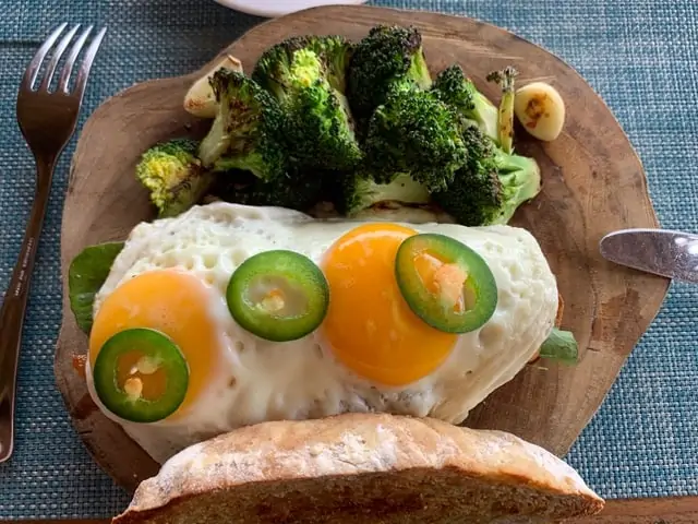 Hotel Punta Islita | The Common Traveler | image: fried egg sandwich with broccoli on wooden plate | Hotel Punta Islita by popular US international travel blog: image of a fried egg sandwich on a wooden plate.