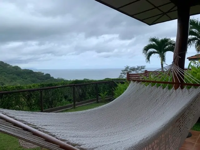 Hotel Punta Islita | The Common Traveler | image: white hammock on lawn with view of Pacific Ocean | Hotel Punta Islita by popular US international travel blog: image of a cream knit hammock.