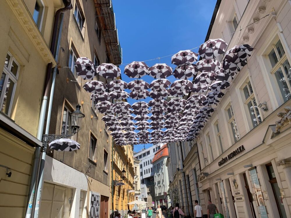 BRATISLAVA TRAVEL GUIDE: THE BEST THINGS TO DO IN 48 HOURS featured by top travel blogger, The Common Traveler. Image: umbrellas over street in Bratislava