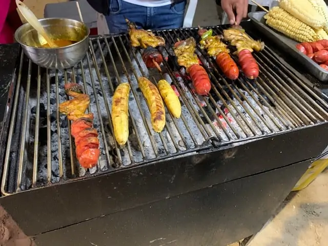 9 BEST THINGS TO DO IN MONTANITA ECUADOR featured by top travel blogger, The Common Traveler | image: plantains, corn cobs, and meat sticks on a grill