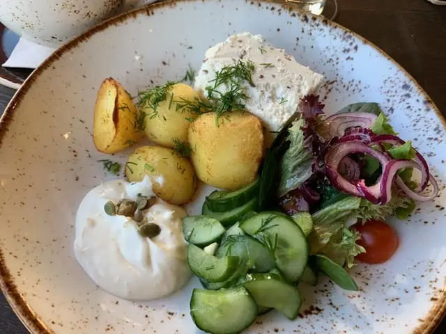 20 Lithuanian Food and Drinks to Try featured by The Common Traveler | image: plate with veggies and butter cream