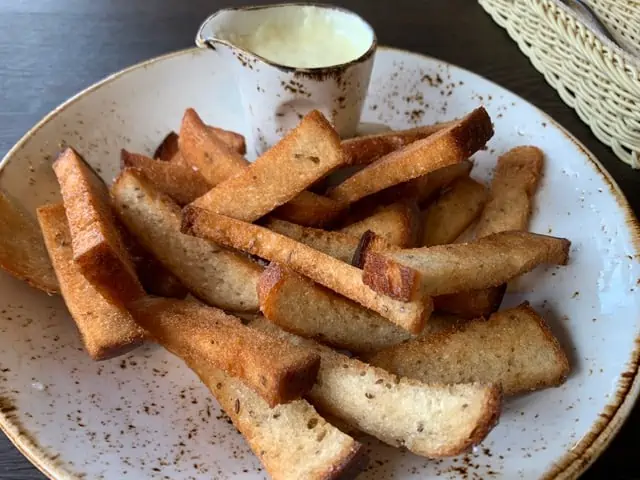 20 Lithuanian Food and Drinks to Try featured by The Common Traveler | image fried bread sticks on a plate