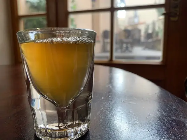 20 Lithuanian Food and Drinks to Try featured by The Common Traveler - image of shot glass of Lithuanian mead on table
