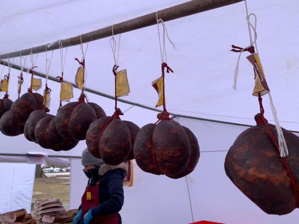 20 Lithuanian Food and Drinks to Try featured by The Common Traveler | image: hanging Skilandis cured sausages