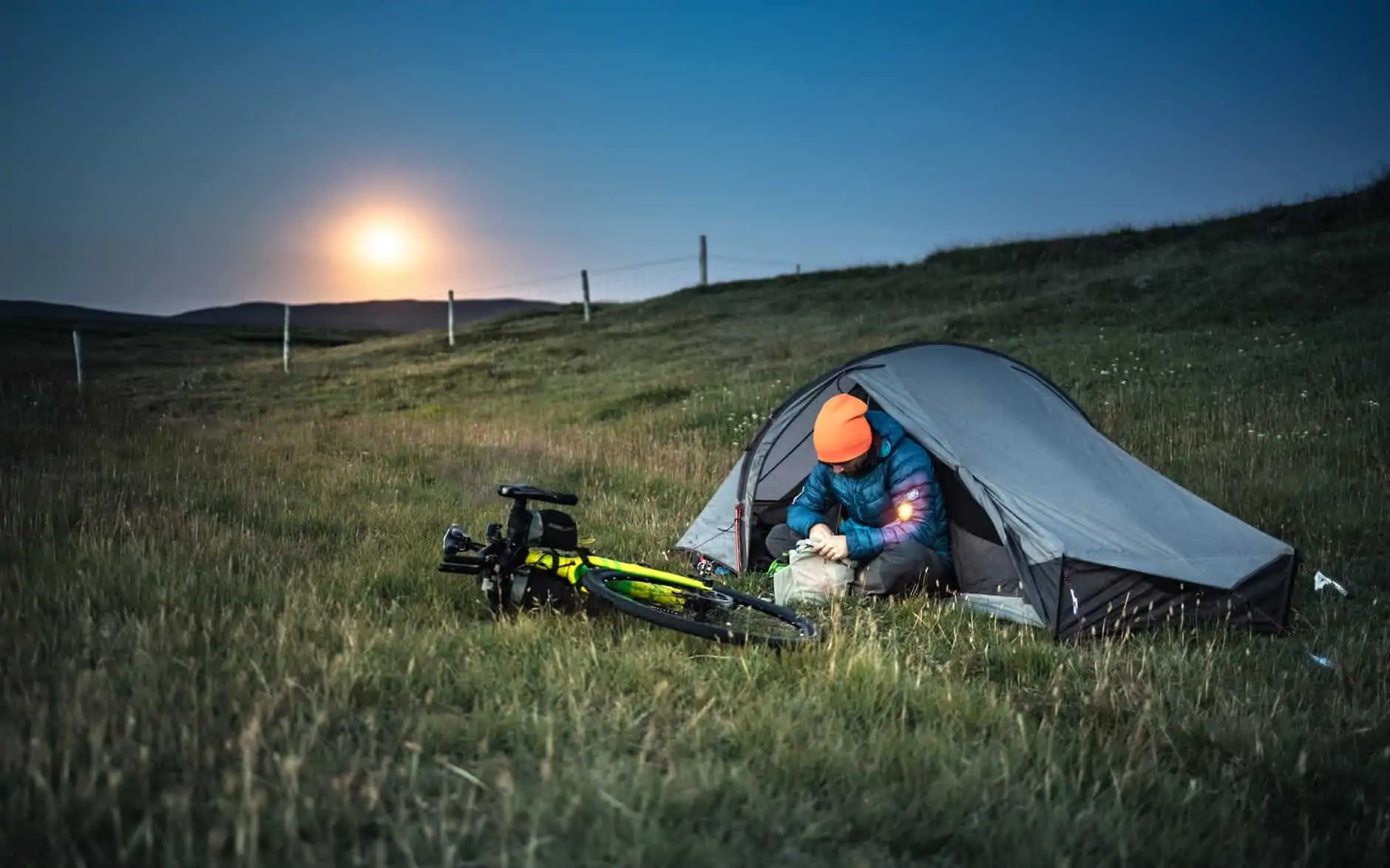 The Common Traveler: How to Get from Vilnius to Riga | image: a man sitting on the tent near his bike