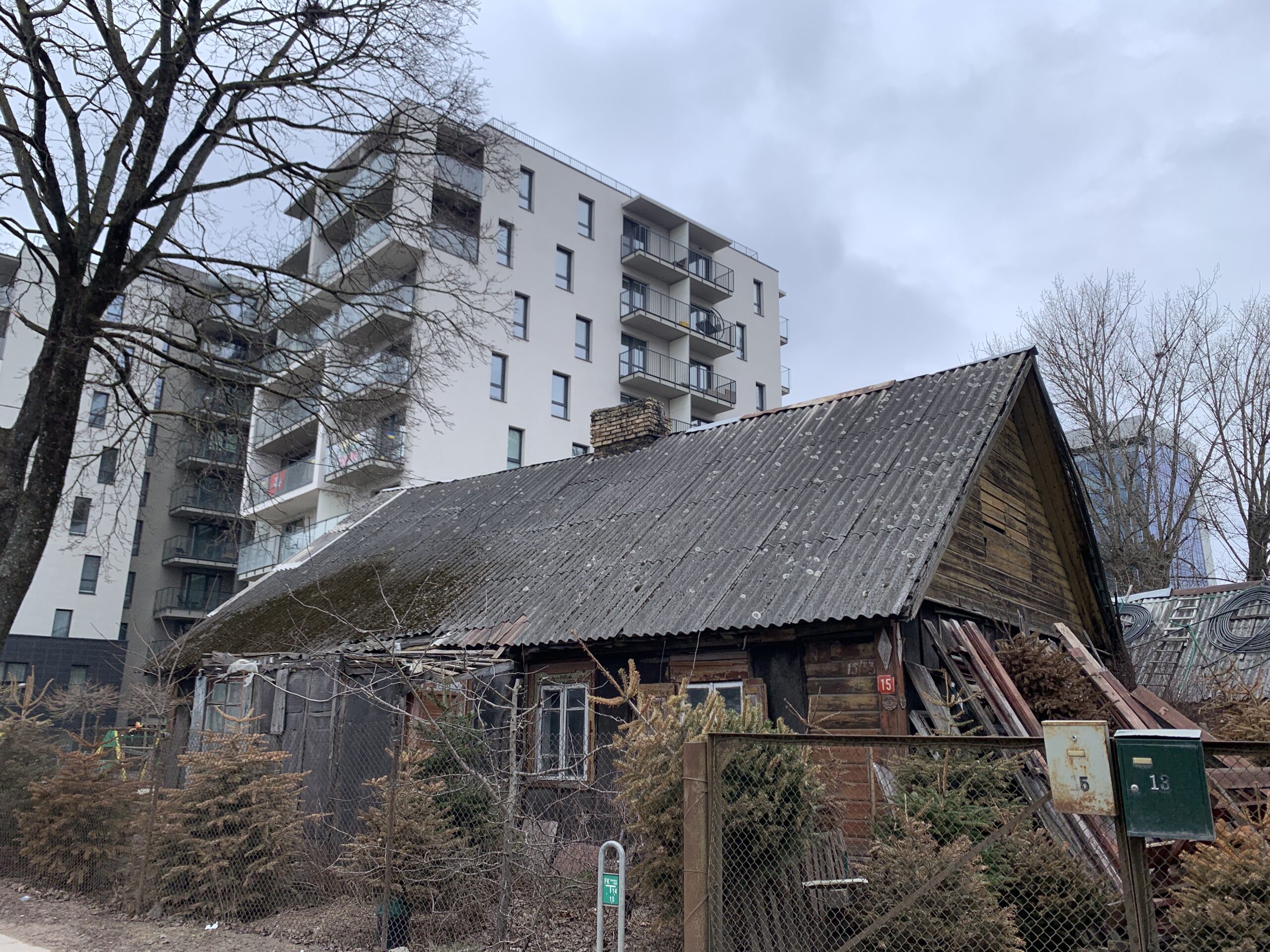 Wooden house with modern building in back in Snipiskes district in Vilnius