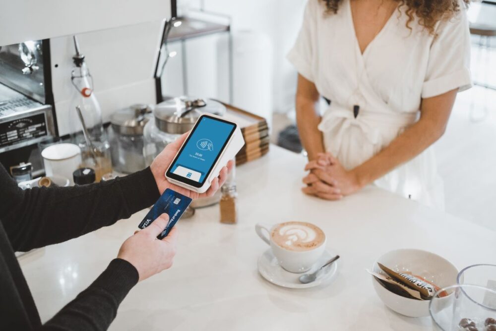 The Common Traveler | How Your Credit Affects Your Travel | image: man paying for coffee with credit card