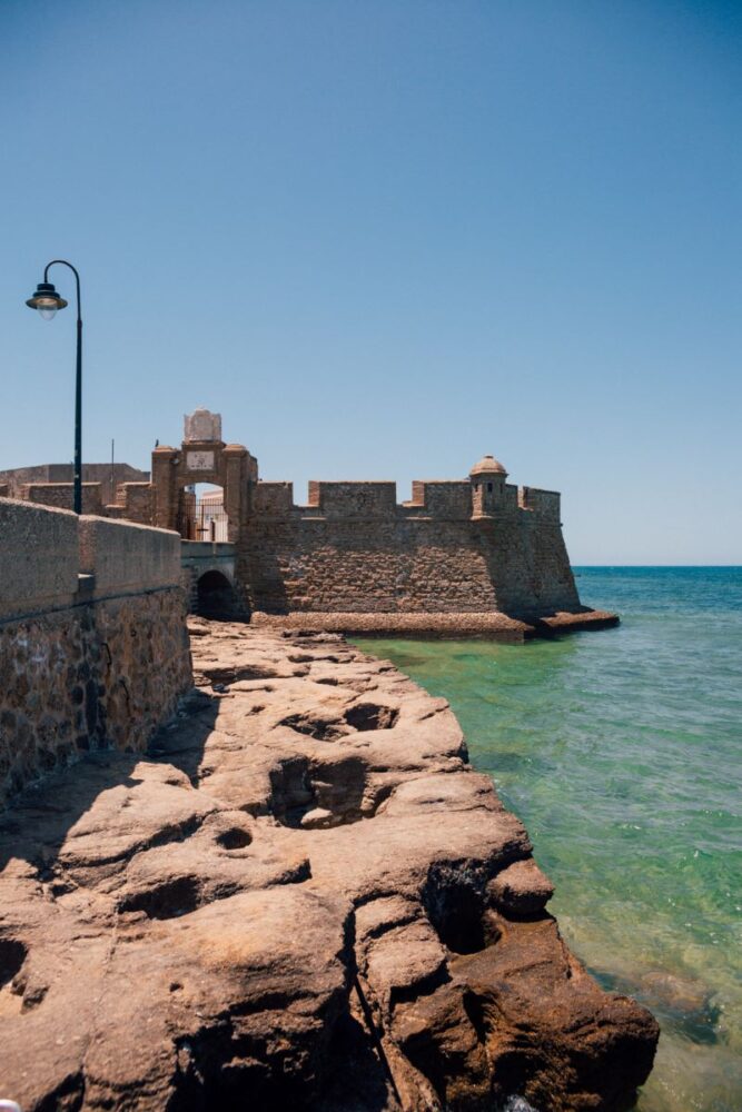 8 Reasons to Visit Cadiz in Spain | The Common Traveler | image: water side of fort walls