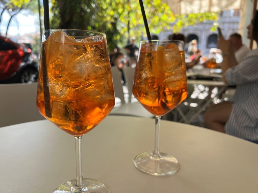 16 Best Things to Do in Rome for First-Time Visitors | The Common Traveler | image: two aperol spritz glasses with coloseum in background