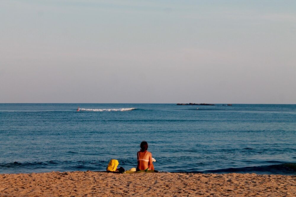 Things to Do in Oaxaca Mexico | The Common Traveler | image: woman sitting on Chacahua Beach