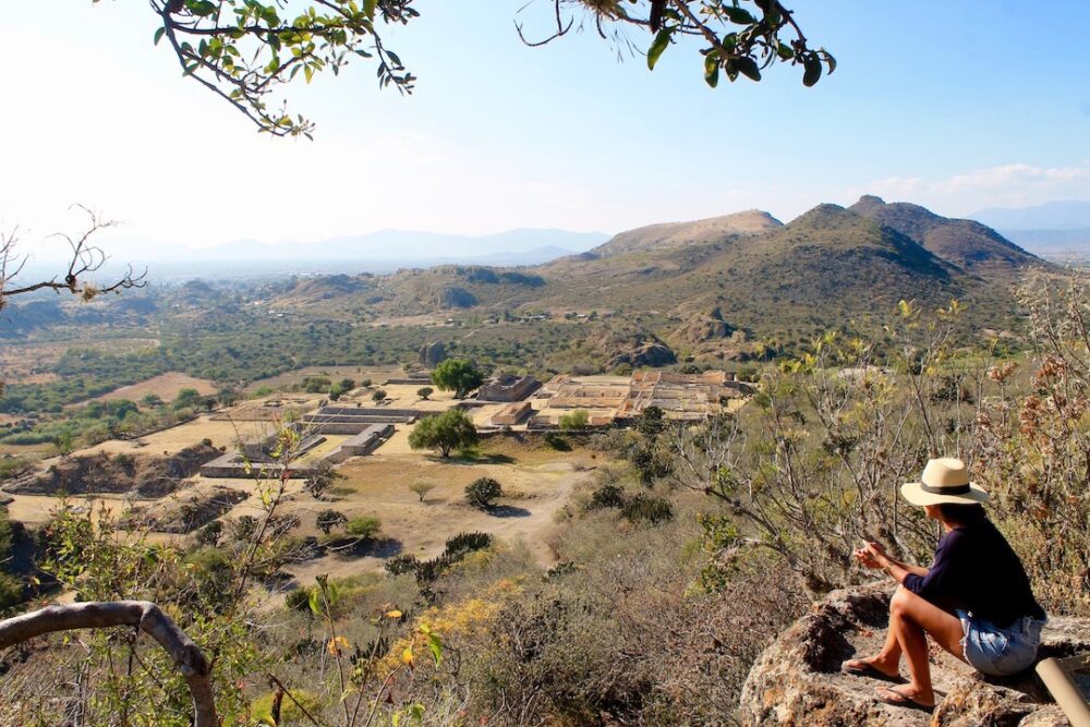 Things to Do in Oaxaca Mexico | The Common Traveler | image: woman looking over ruins at Mitla