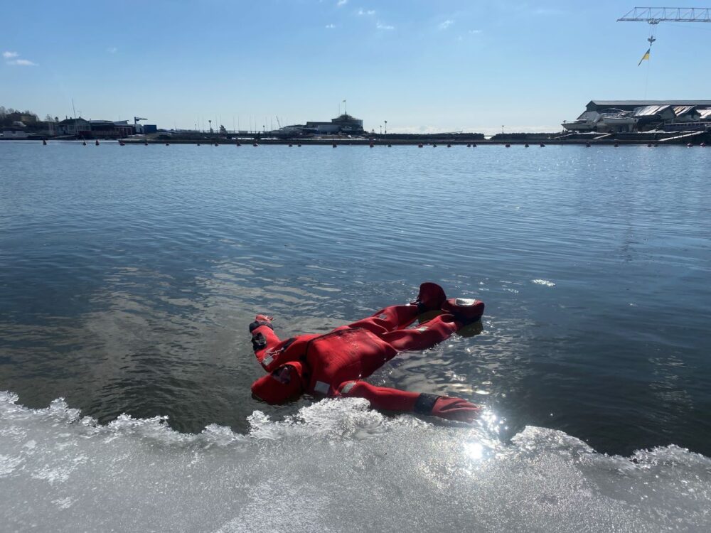 Best Things to Do in Helsinki | The Common Traveler | image: woman in red survival suit floating near ice