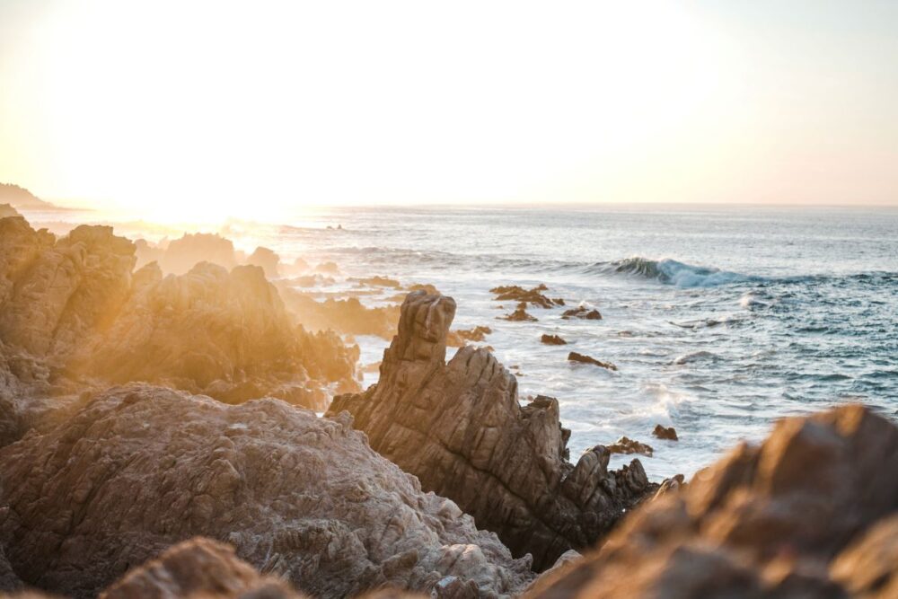 Cabo vs Cancun: Where Should You Go? | The Common Traveler | image: rocks with setting sun in Cabo San Lucas