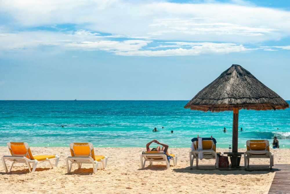 Cabo vs Cancun: Where Should You Go? | The Common Traveler | image: chairs and palapa on Cancun beach