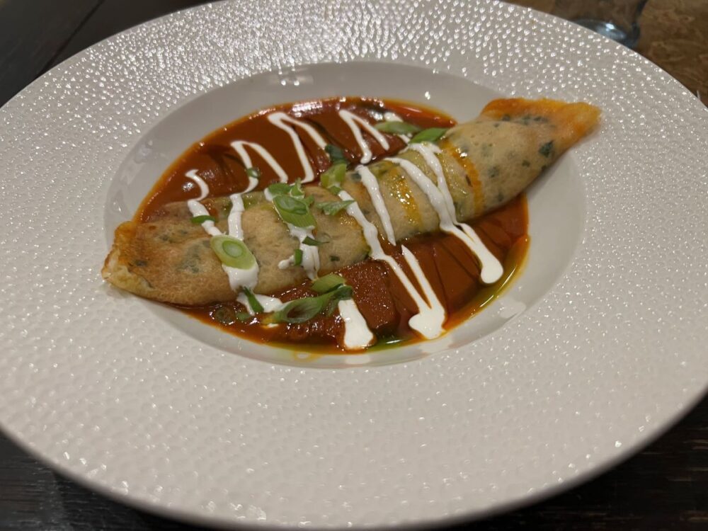 Hungarian Foods and Drinks to Try | The Common Traveler | image: white bowl with pancake with red sauce and cream