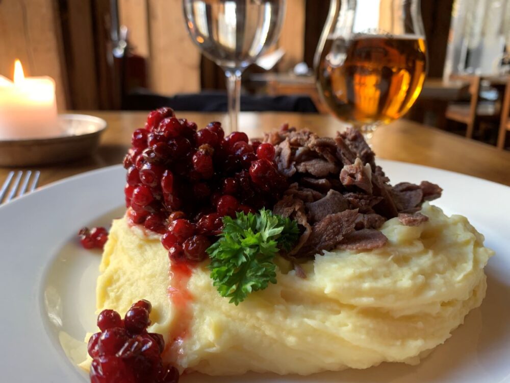 Best Things to Do in Helsinki | The Common Traveler | image: plate with mashed potatoes, reindeer, and red berries