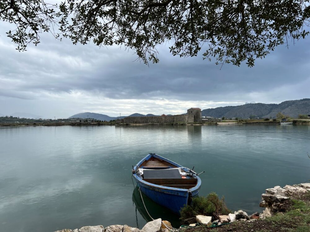 Port Day Guide: Saranda, Albania | The Common Traveler | image: boat on lake with Ali Pasha Castle in background