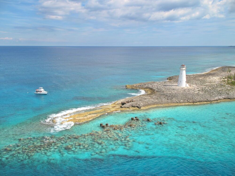 Port Day Guide: Nassau, Bahamas | The Common Traveler | image: lighthouse and boat in rocky beach in Nassau