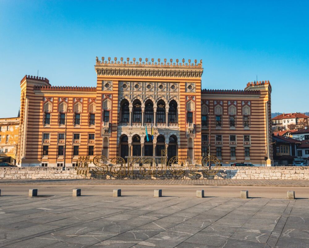 Top Things to Do in Sarajevo | The Common Traveler | image: colorful Town Hall with #sarajevo sign in forefront