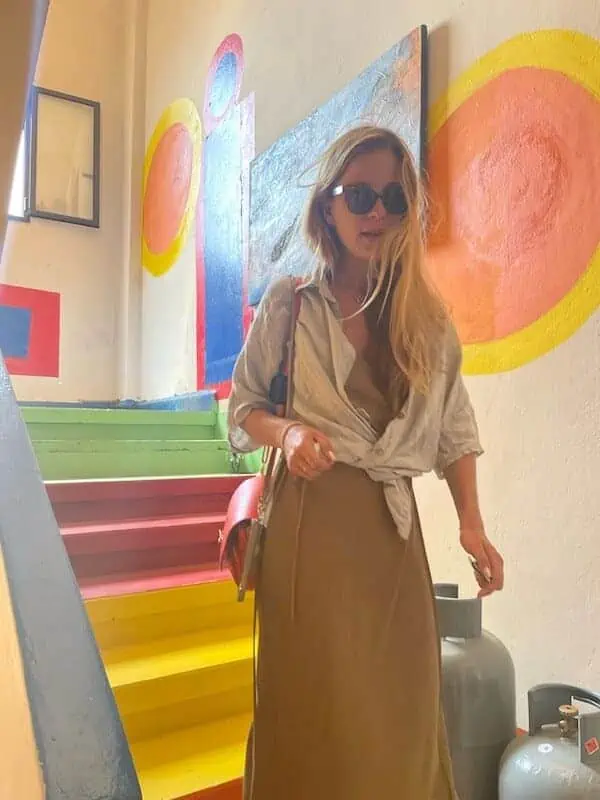 Wanderlust Wardrobe: Packing for Practicality and Style | The Common Traveler | image: travel wardrobe with neutrals, woman in brown dress and shirt 
