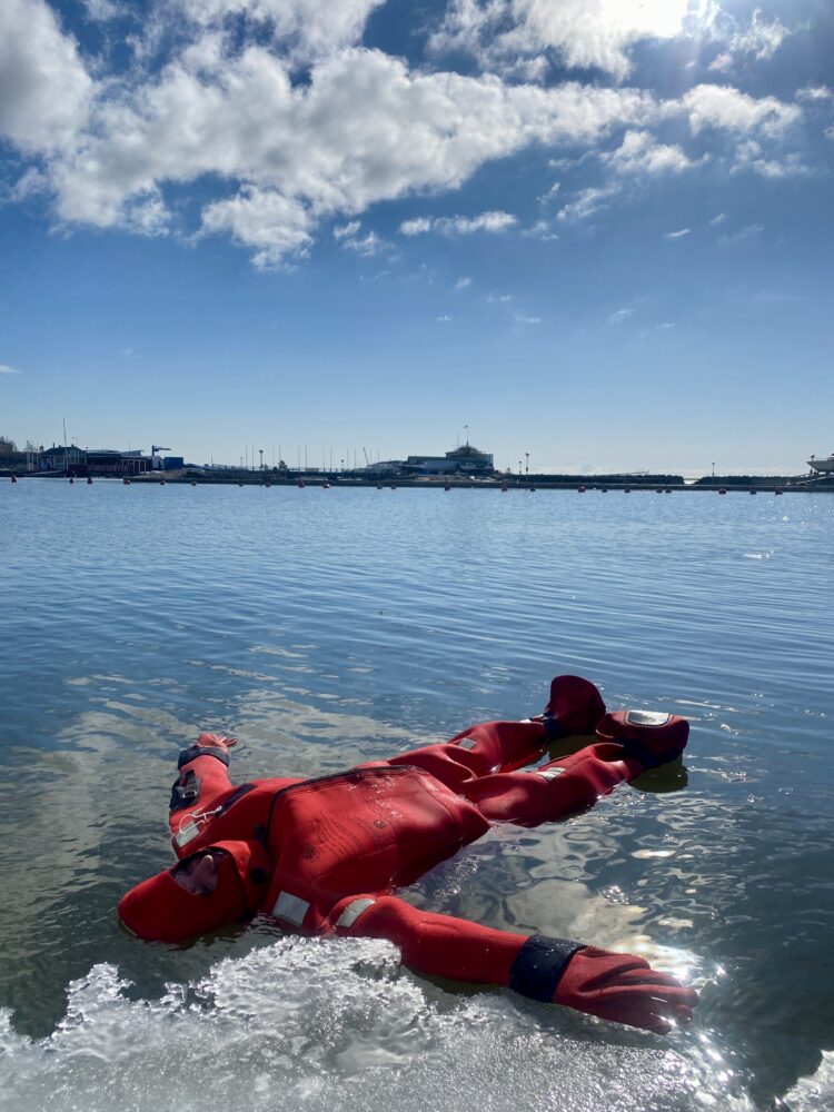 Slower Way To Experience Cities | The Common Traveler | image: woman in red survival suit floating on ice in Baltic Sea