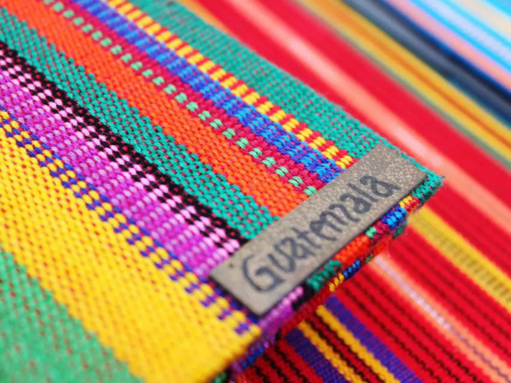 Unforgettable Things to Do in Antigua, Guatemala | The Common Traveler | image: colorful textiles with the word Guatemala