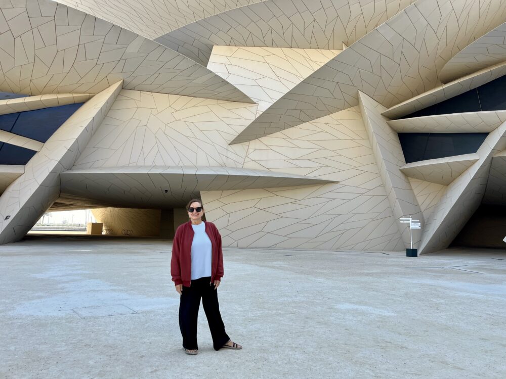 Middle East Packing List for Women | The Common Traveler | image: woman in black pants, blue shirt, red sweatshirt at National Museum of Qatar