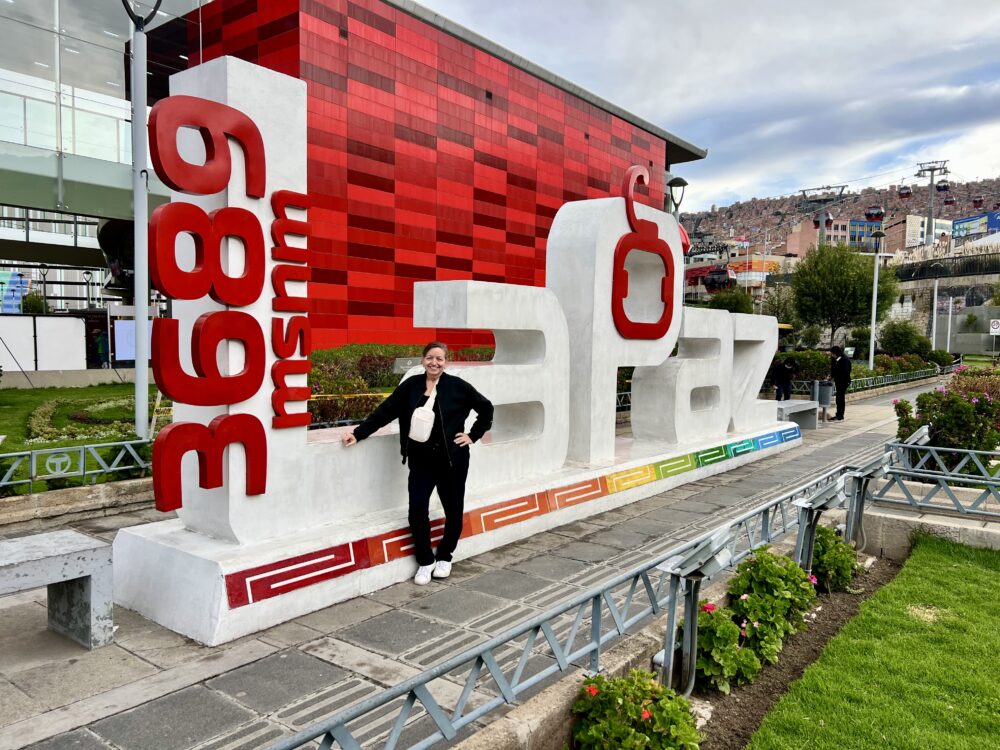 A Traveler's Guide: Tips to Prevent Altitude Sickness | The Common Traveler | image: woman in front of La Paz altitude sign
