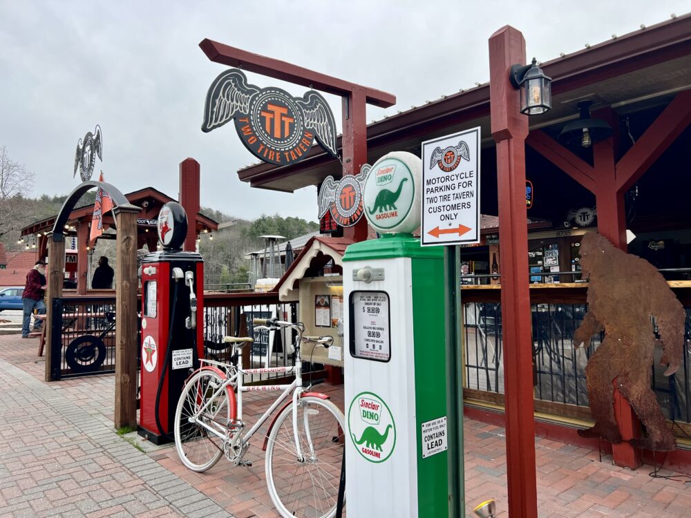 28 Best Things to Do in Helen, GA | The Common Traveler | image: outside of Two Tire Tavern with bike and two gas pumps