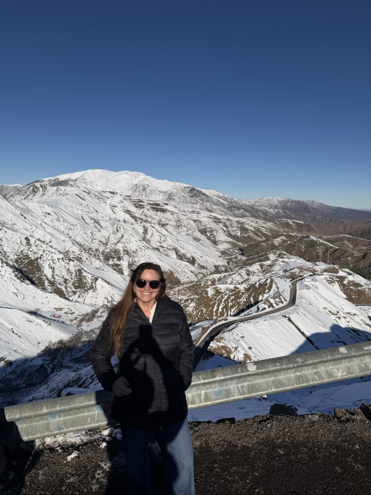 Why December Might Be the Best Time to Visit Marrakech | The Common Traveler | image: woman in black coat on snow covered Atlas Mountains