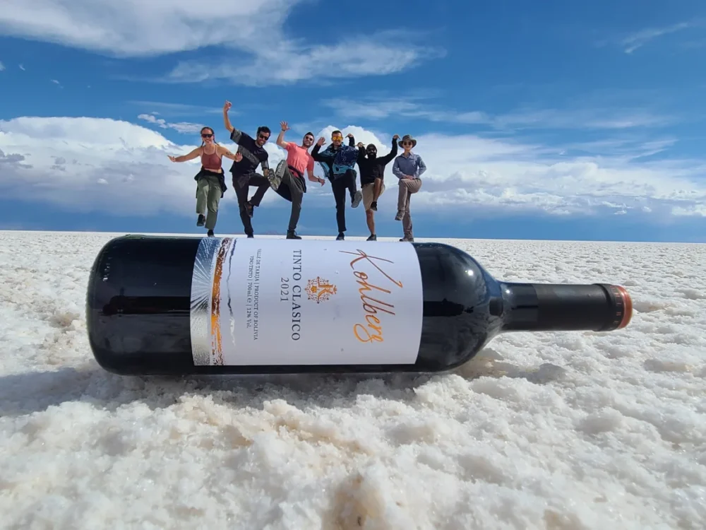Gringo Trail in Bolivia: 5 Places to Escape the Usual Tourist Route | The Common Traveler | image: optical illusion of peole on wine bottle in Salar de Uyuni